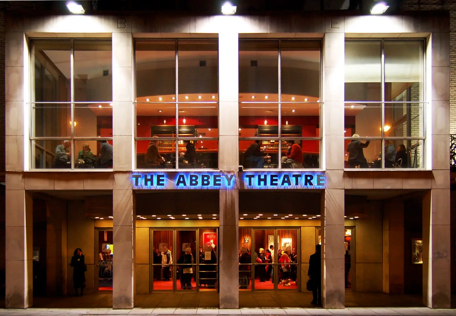 The glass fronted Abbey Theatre in Dublin lit at night with its blue sign